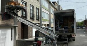 Déménagement à Enghien : lift monte-meubles Knecht Service installé à une fenêtre et camion de déménagement chargé