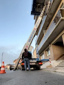 Lift Klaas sur camionnette déployé jusqu’aux balcons d’un immeuble, avec balisage de sécurité – Knecht Service