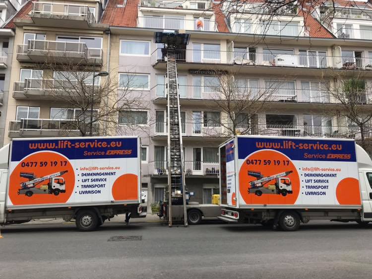 Deux camions de déménagement Knecht Service et un lift installés dans une rue résidentielle