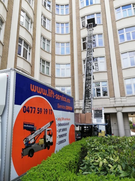 Camion Knecht Service équipé d'un lift monte-meubles devant un immeuble