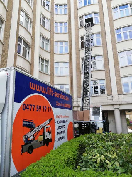 Camion Knecht Service équipé d'un lift monte-meubles devant un immeuble